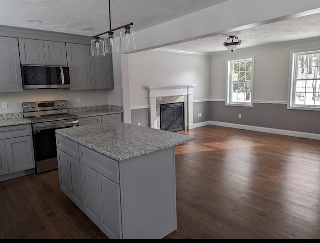 kitchen with appliances with stainless steel finishes, dark wood-type flooring, and gray cabinetry