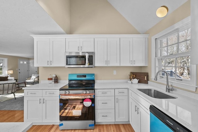 kitchen with white cabinetry, a healthy amount of sunlight, appliances with stainless steel finishes, and sink