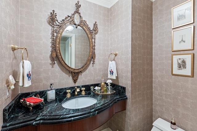 bathroom with toilet, tile walls, sink, and crown molding