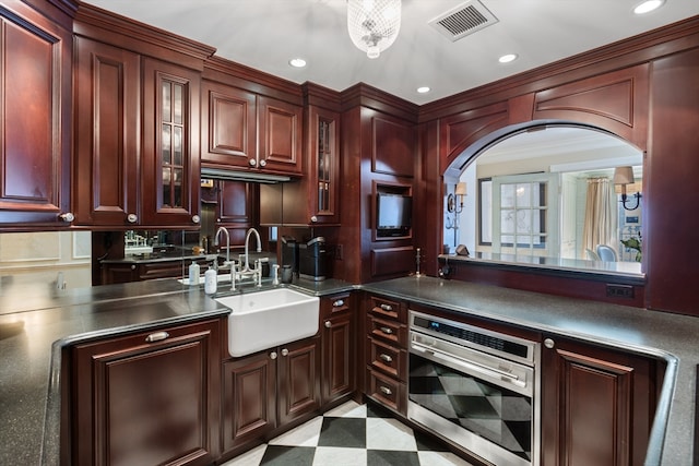 kitchen with stainless steel oven, sink, and ornamental molding