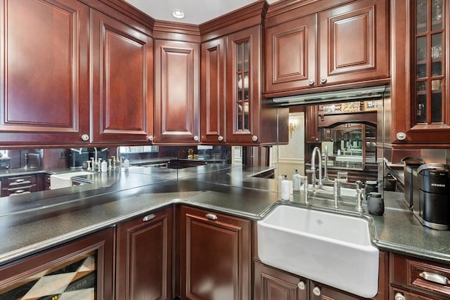 300 Boylston St Unit 517, Boston, MA 02116 - kitchen with a sink, dark countertops, glass insert cabinets, and reddish brown cabinets