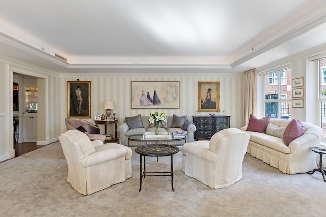 carpeted living room featuring ornamental molding and a raised ceiling