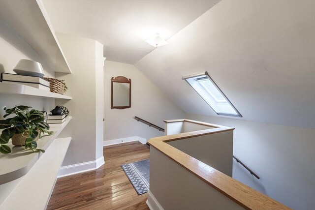 61 Crescent St Unit 6, Northampton, MA 01060 - hall featuring an upstairs landing, a skylight, vaulted ceiling, wood finished floors, and baseboards