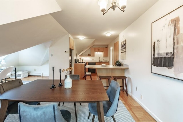 61 Crescent St Unit 6, Northampton, MA 01060 - dining space with a chandelier, a baseboard heating unit, light wood finished floors, vaulted ceiling, and baseboards