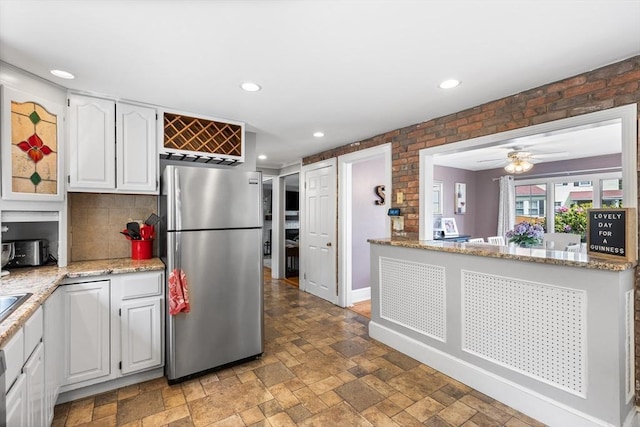 212 Broadway St, Wakefield, MA 01880 - kitchen featuring freestanding refrigerator, white cabinetry, light stone finish floors, recessed lighting, and backsplash