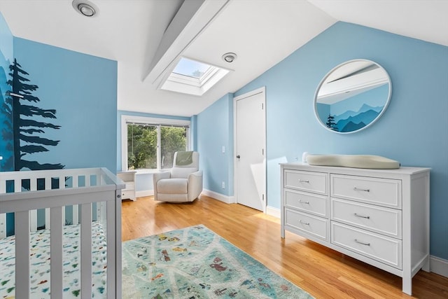 212 Broadway St, Wakefield, MA 01880 - bedroom with a skylight, vaulted ceiling, light wood-style floors, a nursery area, and baseboards