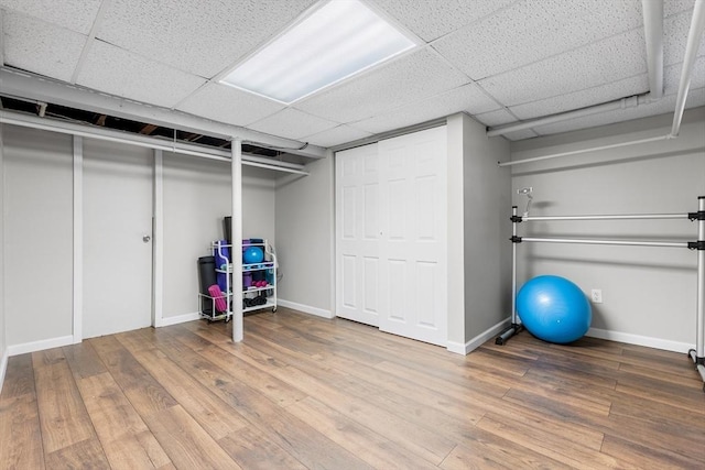 212 Broadway St, Wakefield, MA 01880 - finished basement with baseboards, wood-type flooring, and a paneled ceiling