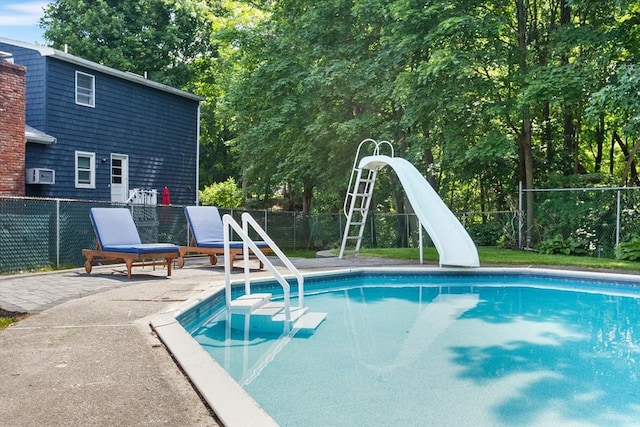 212 Broadway St, Wakefield, MA 01880 - view of swimming pool with a water slide, a patio, and view of wooded area