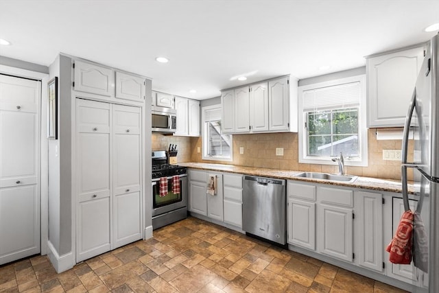 212 Broadway St, Wakefield, MA 01880 - kitchen with stainless steel appliances, a sink, tasteful backsplash, recessed lighting, and stone finish floors