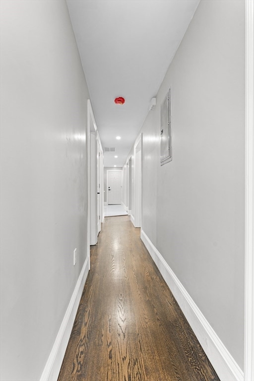 corridor with electric panel and dark wood-type flooring