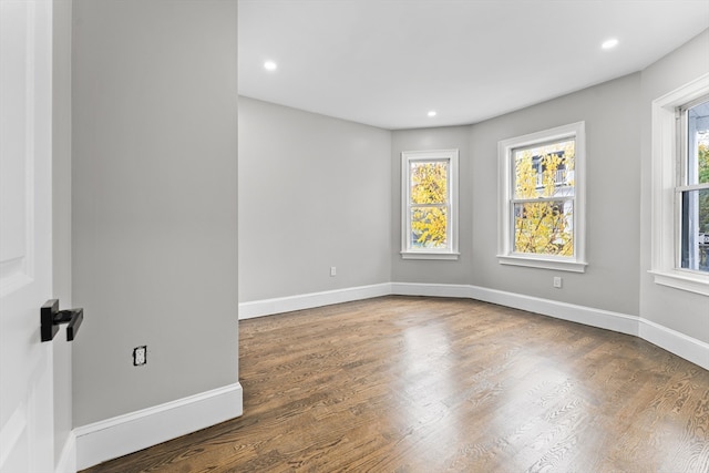 spare room with dark wood-type flooring and a wealth of natural light