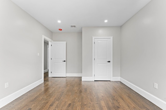 unfurnished room with dark wood-type flooring