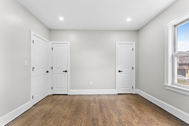 empty room featuring dark hardwood / wood-style flooring and a wealth of natural light