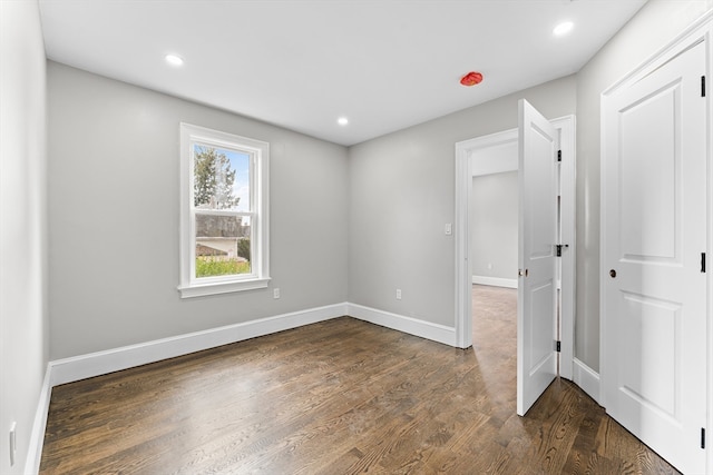 unfurnished room with dark hardwood / wood-style flooring