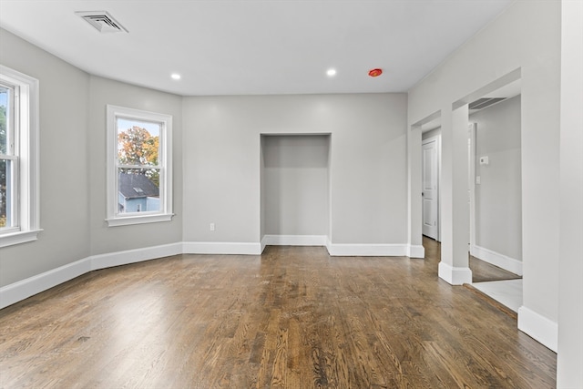 unfurnished room with dark wood-type flooring