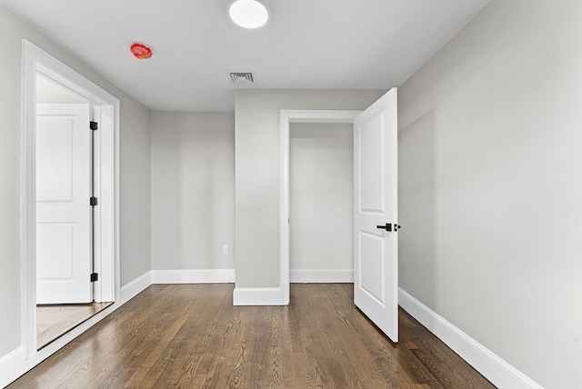 unfurnished bedroom featuring dark hardwood / wood-style floors