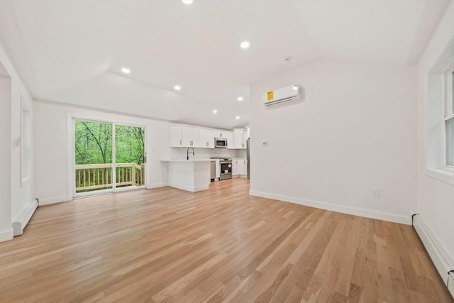 unfurnished living room featuring lofted ceiling, baseboards, light wood-style flooring, and a wall mounted AC