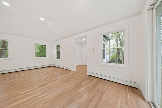 unfurnished room with a baseboard heating unit, a wealth of natural light, recessed lighting, and light wood-type flooring