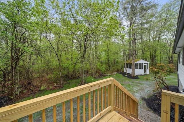 wooden deck featuring a sunroom and a view of trees