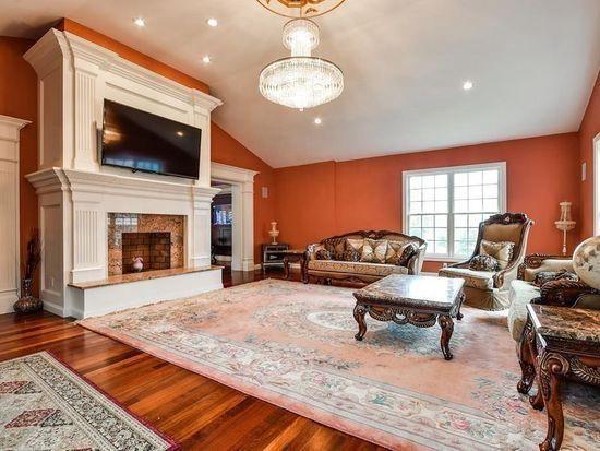 3 Regency Rdg, Andover, MA 01810 - living area with a high end fireplace, wood finished floors, vaulted ceiling, a chandelier, and recessed lighting