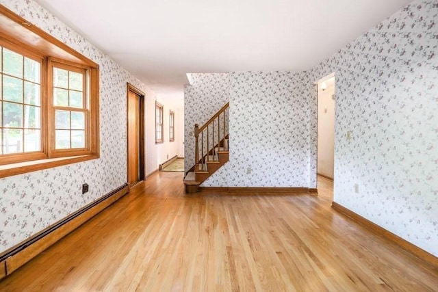 unfurnished room featuring light hardwood / wood-style floors and a baseboard heating unit