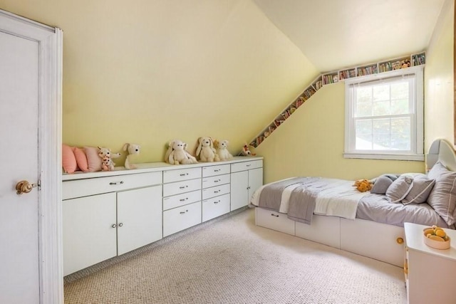 bedroom featuring light colored carpet and vaulted ceiling