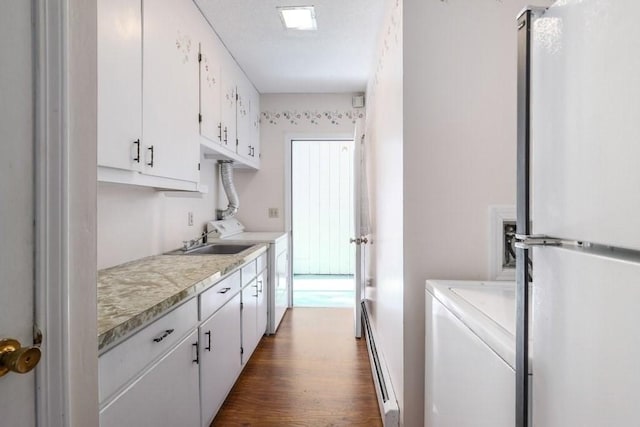 kitchen featuring stainless steel fridge, dark hardwood / wood-style flooring, sink, a baseboard radiator, and white cabinetry