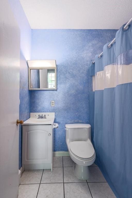 bathroom with tile patterned flooring, a shower with curtain, vanity, and toilet