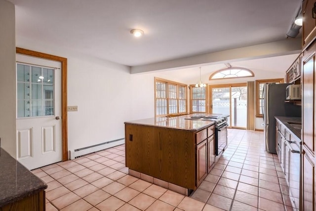 kitchen with stainless steel appliances, a baseboard heating unit, a chandelier, a kitchen island, and light tile patterned flooring