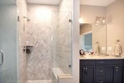 bathroom featuring double vanity and a shower stall