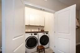 washroom with cabinet space and washing machine and clothes dryer