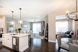 kitchen featuring dishwasher, a sink, white cabinets, and a healthy amount of sunlight