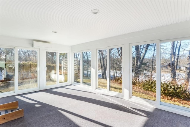 unfurnished sunroom with plenty of natural light and an AC wall unit