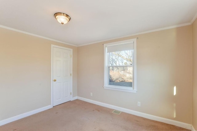 empty room featuring ornamental molding and light colored carpet