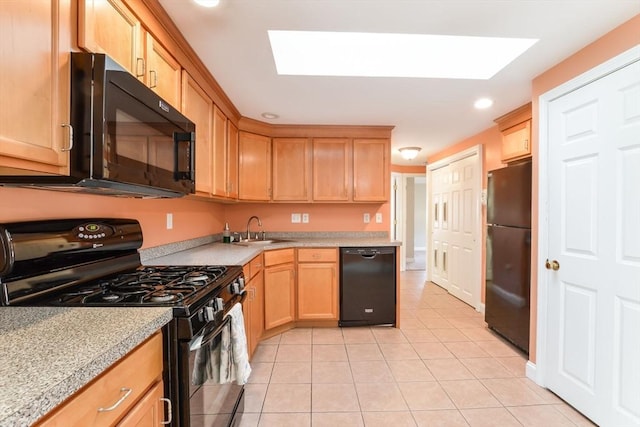 kitchen with light tile patterned flooring, a skylight, sink, and black appliances