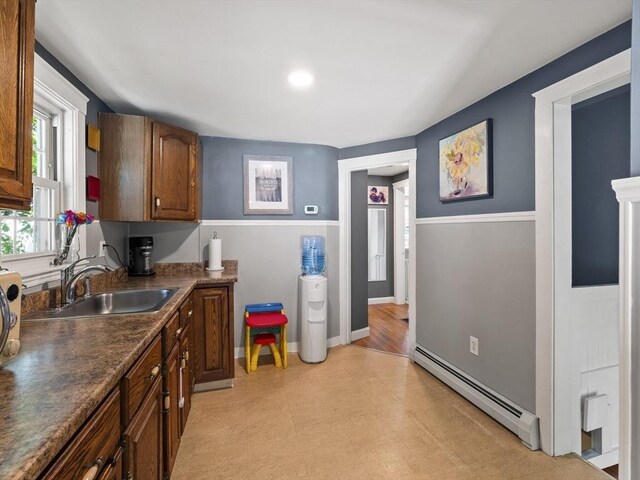307 Boutelle St, Fitchburg, MA 01420 - kitchen featuring a baseboard heating unit, dark countertops, light floors, and brown cabinetry