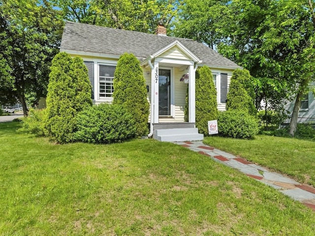 307 Boutelle St, Fitchburg, MA 01420 - bungalow featuring a front yard, a chimney, and roof with shingles