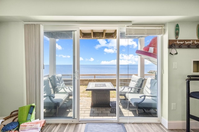 doorway with a water view and hardwood / wood-style floors