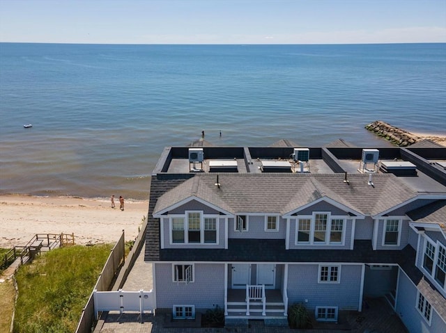drone / aerial view with a water view and a beach view