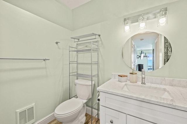 bathroom featuring baseboards, visible vents, toilet, and vanity