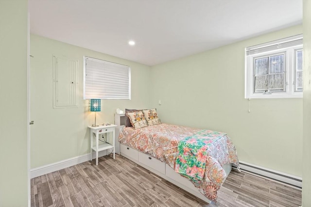 bedroom with recessed lighting, baseboards, a baseboard heating unit, and wood finished floors