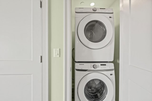 washroom with stacked washer / drying machine and laundry area