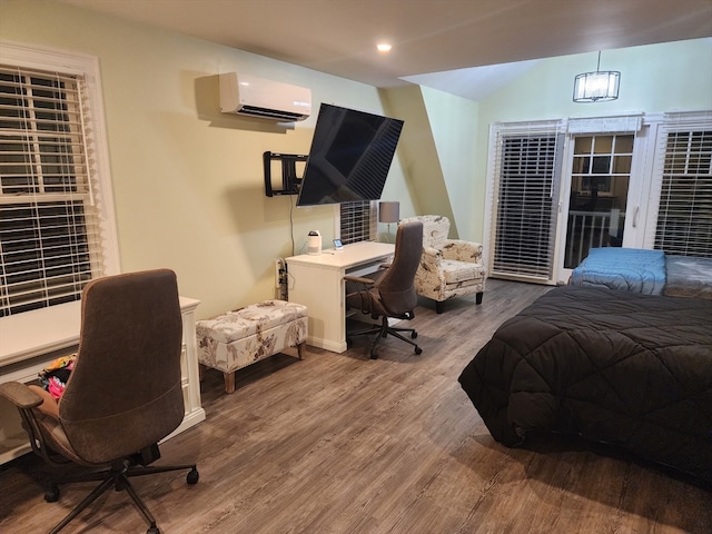 bedroom with hardwood / wood-style floors and a wall unit AC