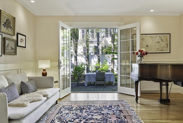 interior space with french doors, light wood-type flooring, and ornamental molding