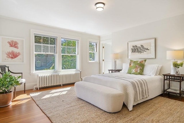 bedroom featuring hardwood / wood-style flooring and radiator