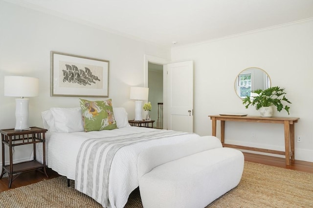 bedroom with wood-type flooring and ornamental molding