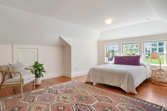 bedroom featuring wood-type flooring and lofted ceiling