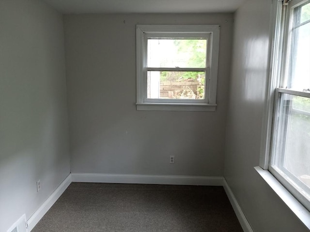 carpeted spare room featuring visible vents and baseboards