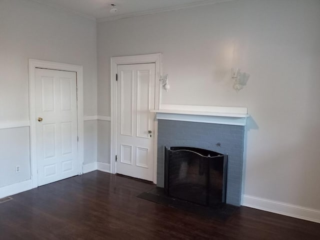 unfurnished living room featuring a brick fireplace, baseboards, and wood finished floors