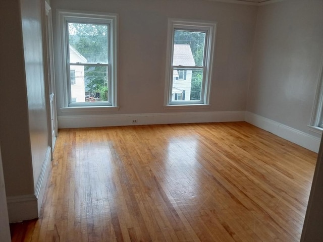 empty room with light wood-style flooring and baseboards